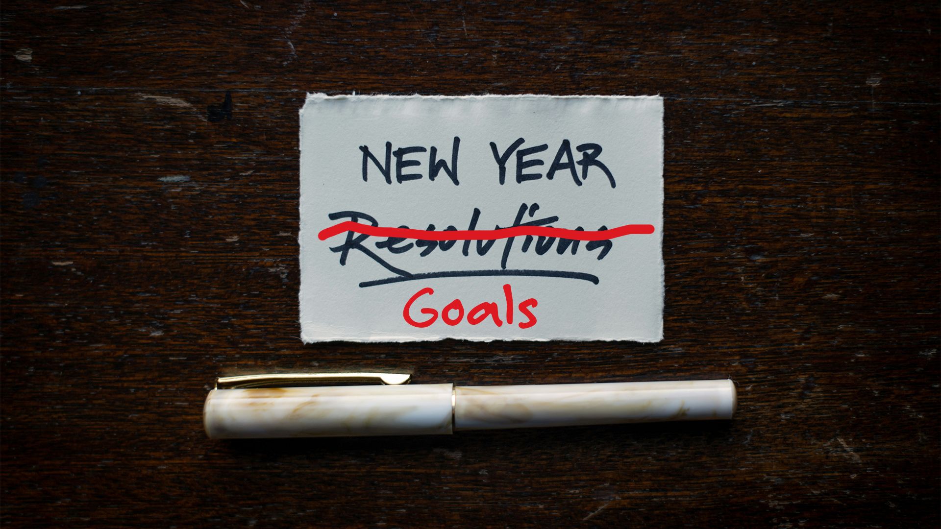 Photo of a piece of paper that says New Year Goals and the word resolutions crossed out